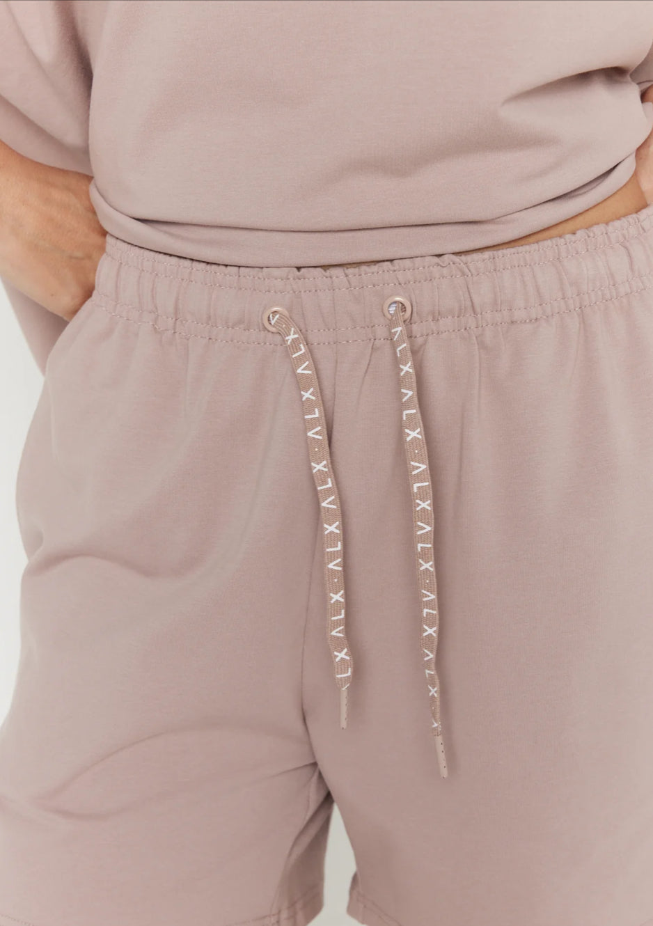Mauve shorts with drawstring and brand logo on a white background