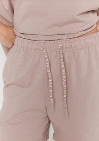Mauve shorts with drawstring and brand logo on a white background