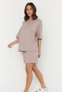 Woman wearing a beige outfit on a white background