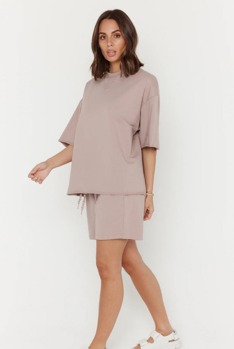 Woman wearing a beige outfit on a white background