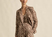 Person wearing a leopard print outfit against a neutral background