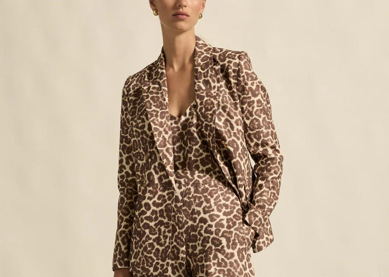 Person wearing a leopard print outfit against a neutral background
