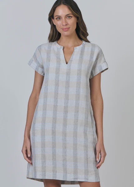Woman wearing a checkered dress on a plain background