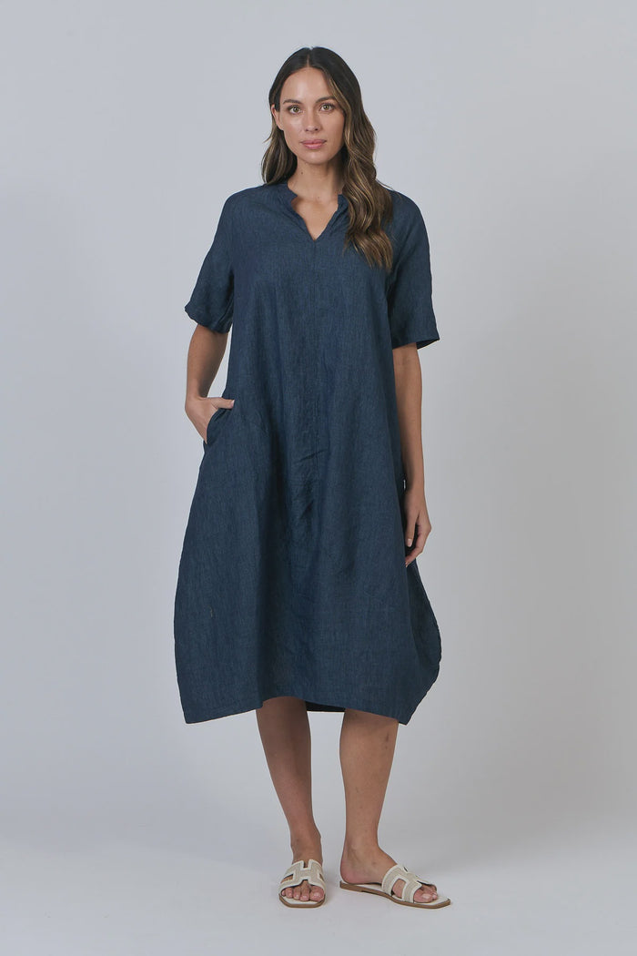 Woman wearing a blue dress against a plain background