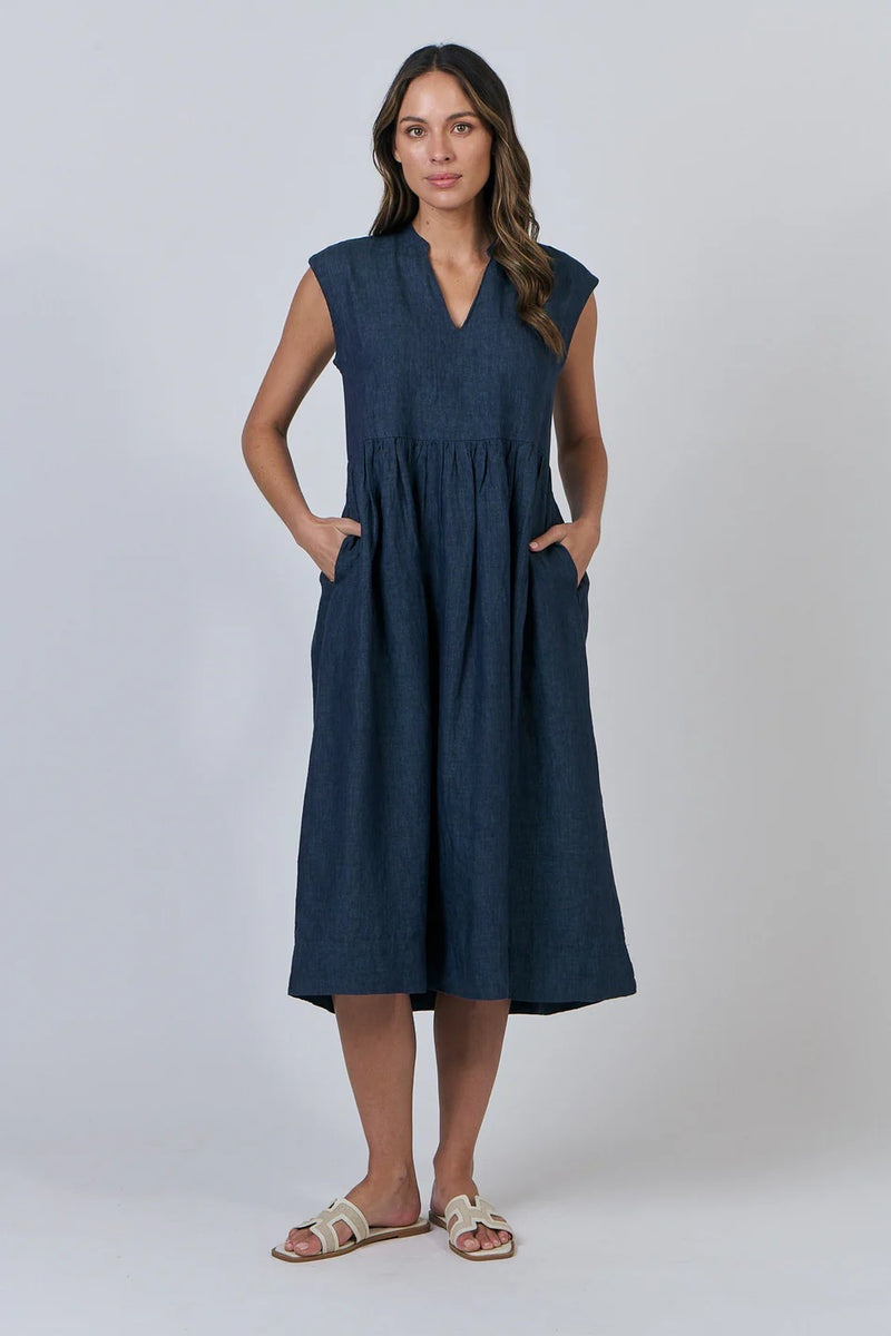 Woman wearing a navy sleeveless dress on a white background