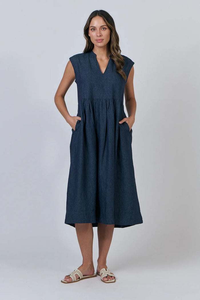 Woman wearing a navy sleeveless dress on a white background