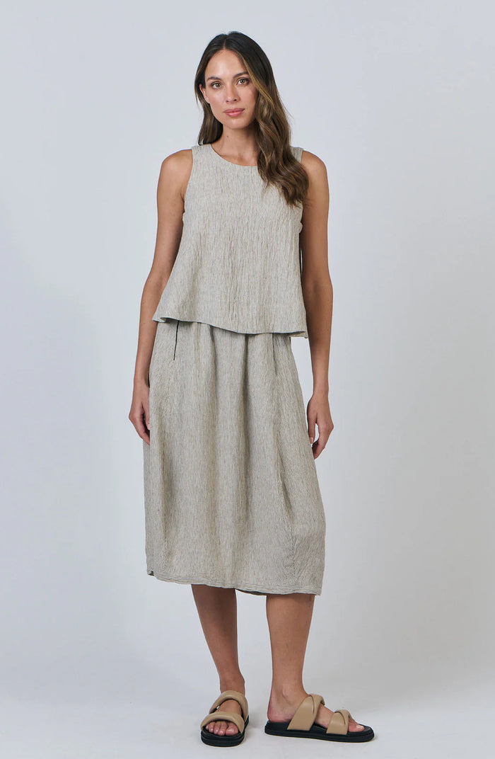 Woman wearing a sleeveless top and long skirt set on a white background