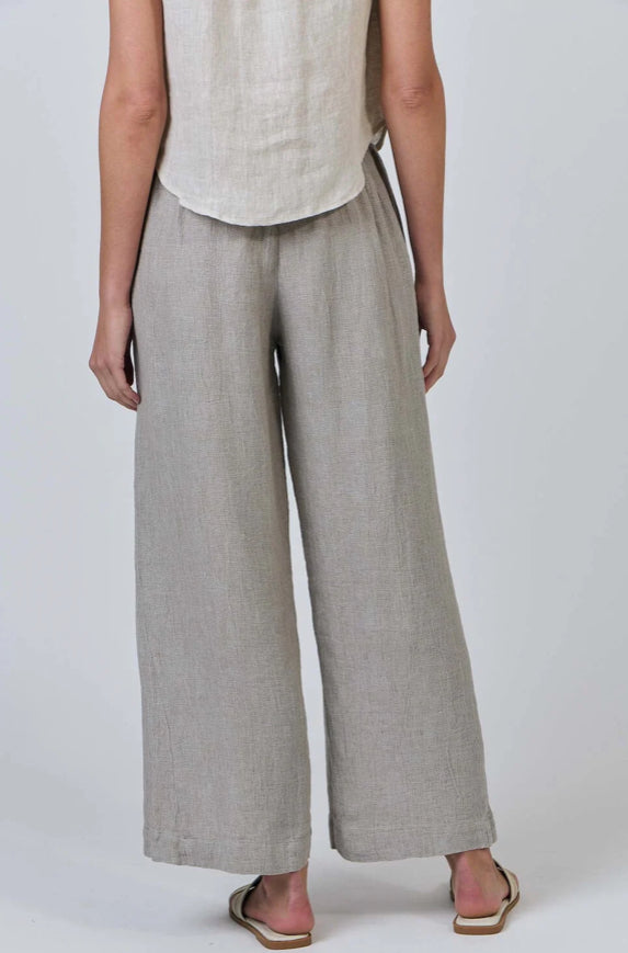 Person wearing light gray wide-leg pants and a sleeveless top on a white background