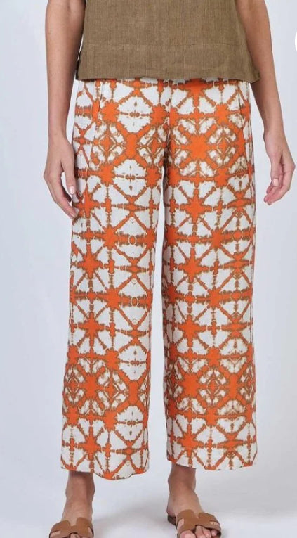 Person wearing orange and white patterned pants on a white background