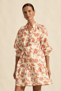 Woman wearing a floral dress against a beige background