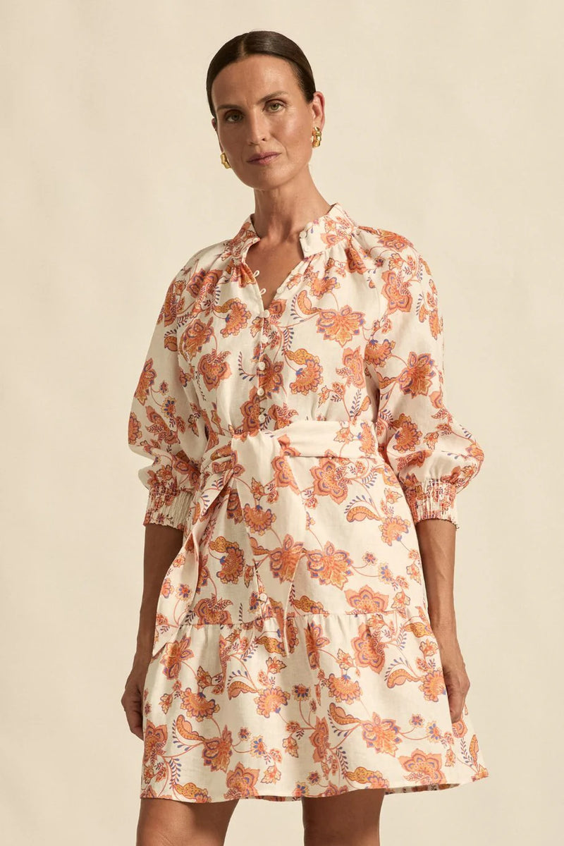 Woman wearing a floral dress against a beige background