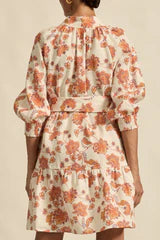 Woman wearing a floral dress with long sleeves on a beige background