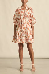 Woman wearing a floral dress against a plain background