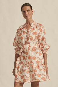 Woman wearing a floral dress against a beige background