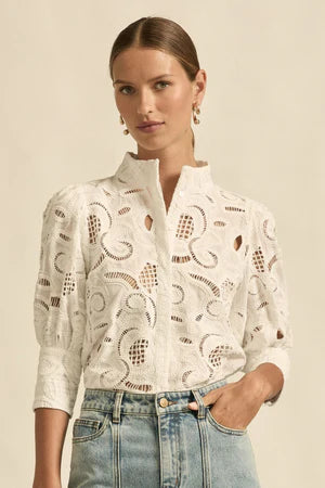 Woman wearing a white lace blouse with a beige background