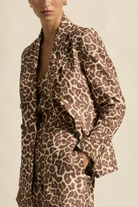 Leopard print jacket worn by a person on a beige background