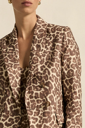 Leopard print blazer worn by a person on a beige background