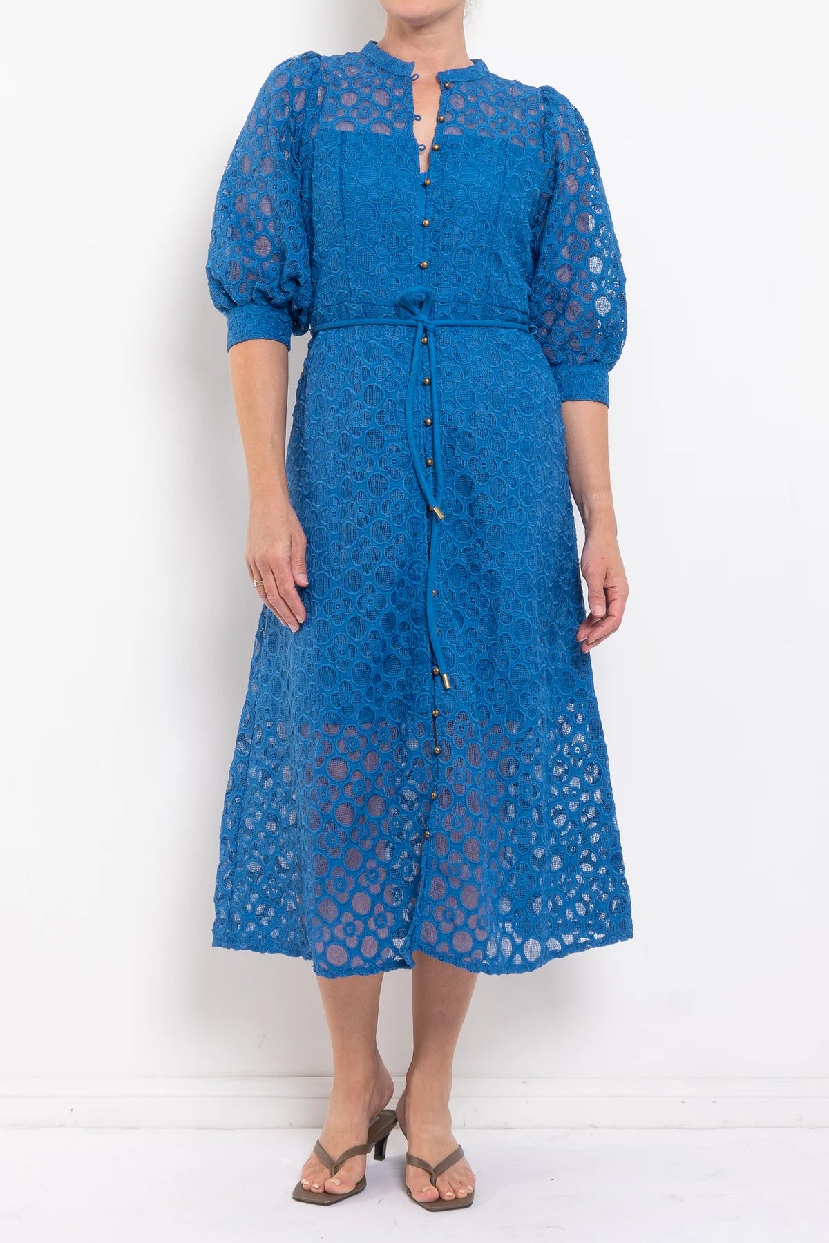 Blue lace dress worn by a person on a white background