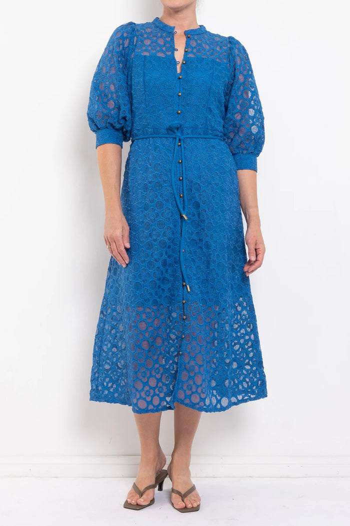 Blue lace dress worn by a person on a white background
